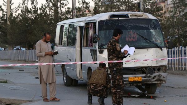 Afghan security personnel investigate a damage bus  (AFP)
