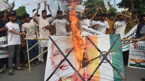 Pakistani activists of the "Youth Forum for Kashmir" group shout slogans as a a picture of Indian Prime Minister Narendra Modi and Indian flag is burned during a protest in Lahore on August 5, 2019. (AFP/ File Photo)