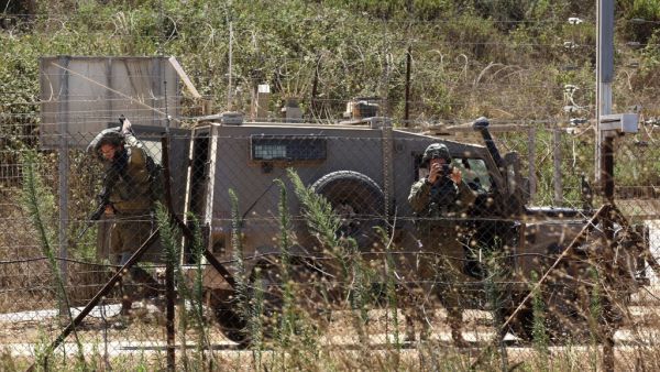 Lebanese village of Kfar Kila shows Israeli soldiers behind the border fence in the Israeli village of Mutella. (Mahmoud ZAYYAT / AFP)
