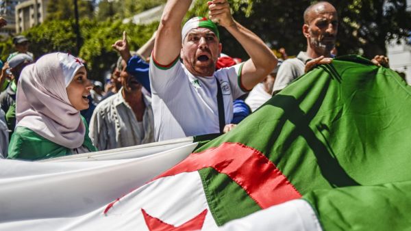 Algerian demonstrators chant slogans and march with national flags as they gather in the streets of the capital Algiers. (AFP/ File Photo)