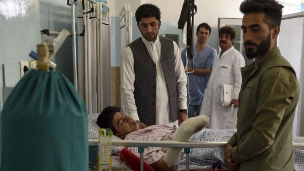 A wounded man receives treatment as people gather around him at the Wazir Akbar Khan hospital after a deadly bomb blast in a wedding hall in Kabul on August 18, 2019. (AFP/ File Photo)