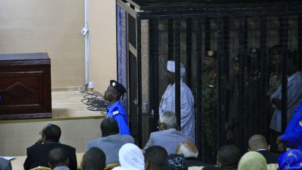 Sudan's deposed military ruler Omar al-Bashir stands in a defendant's cage during the opening of his corruption trial in Khartoum on August 19, 2019.  (AFP/ File Photo)