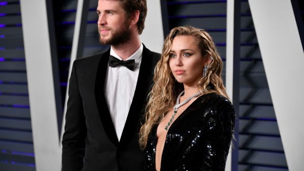 Liam Hemsworth (L) and Miley Cyrus attend the 2019 Vanity Fair Oscar Party hosted by Radhika Jones at Wallis Annenberg Center for the Performing Arts in Beverly Hills, California. (AFP)