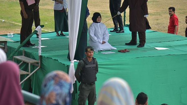 One woman pleading for the masked sharia officer to stop because she could not bear the pain. (AFP)