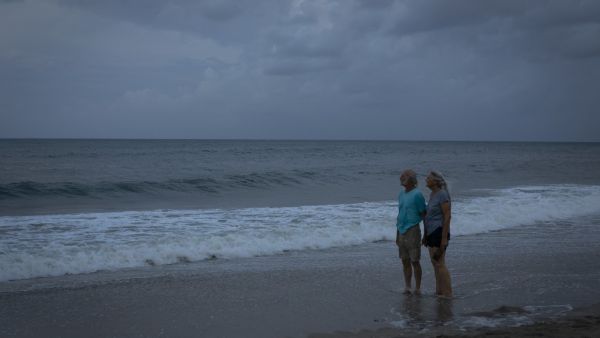 Two elders looks at the ocean after a pouring rain while there are mandatory evacuation orders for parts of Palm Beach County in Lantana Beach, Florida on September 1, 2019.  (AFP/ File Photo)