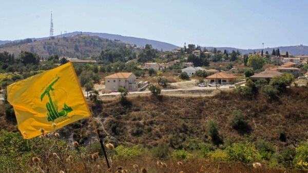 A Hezbolla flag flutters in the Khiyam plain on the Lebanese side of the border with Israel   (AFP)