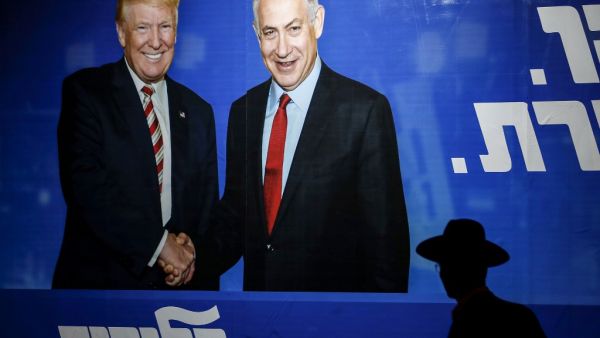 An Ultra-Orthodox Jewish man walks beneath an Israeli election billboard for the Likud party showing US President Donald Trump shaking hands with Likud chairman and Prime Minister Benjamin Netanyahu in Jerusalem on September 9, 2019. (AHMAD GHARABLI / AFP)