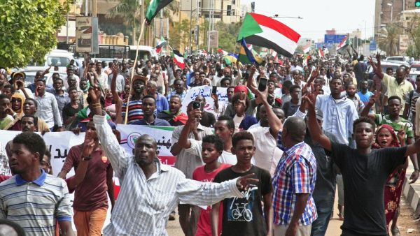 People wave the old and current flags of Sudan as they chant slogans during a mass demonstration near the presidential palace in Sudan's capital Khartoum on September 12, 2019, calling for the appointment of a new permanent chief of judiciary and prosecutor general. (AFP/ File Photo)