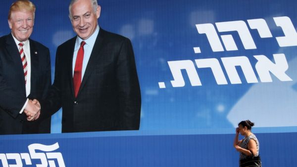 A woman walks past an Israeli election billboard for the Likud party showing US President Donald Trump shaking hands with Likud chairman and Prime Minister Benjamin Netanyahu with a caption in Hebrew reading "Netanyahu, in another league", in the Israeli coastal city of Tel Aviv on September 12, 2019. (AFP)