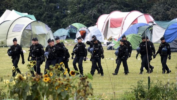 French gendarmes walk by tents during the evacuation of the Grande Synthe migrant camp, northern France, on September 17, 2019. (FRANCOIS LO PRESTI / AFP)