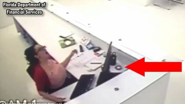 Sheyla White tried to fake a workplace injury after a sprinkler head fell onto her desk (indicated by the red arrow). She said it bounced up and hit her. (Screenshot/ Video)