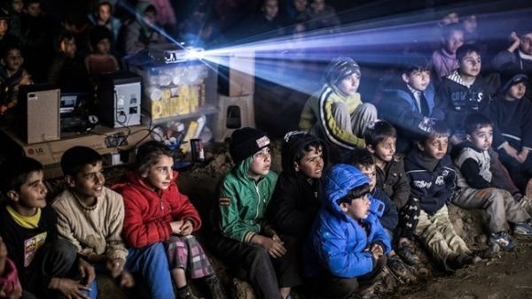 Ali Noureddine's photo captures refugee children watching a movie in a kids-only cinema at the Eidomeni refugee camp at the Greek-Macedonian border. (Photo by Ali Noureddine, courtesy of Beirut Image Festival)