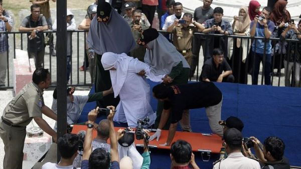 Indonesian woman collapses in pain (Twitter)
