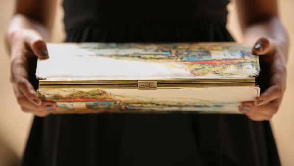 Youssef El-Hadi ingeniously incorporates a selection of Celia’s vivid paintings onto small clutches and handbags. (Supplied)