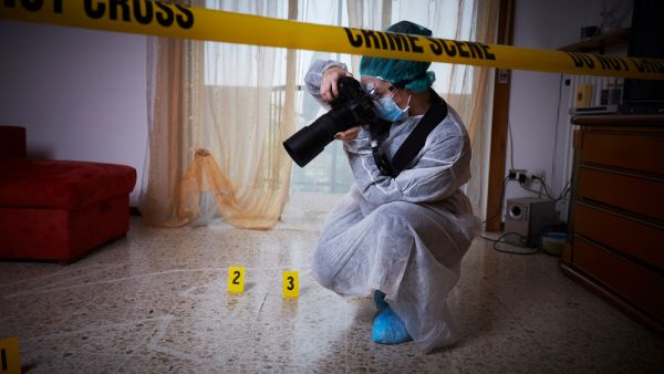 Forensics researcher photographing a blood at a murder scene. (Shutterstock/ File Photo)