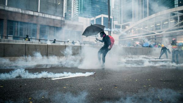 Protesters react after police fired tear gas outside the government headquarters in Hong Kong (AFP)