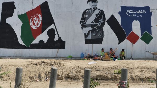 Workers take rest next to a mural of late king of Afghanistan Aman Ullah Khan, who led the successful war for Afghanistan's independence from British Rule in 1919, the day after Afghanistan held presidential elections, in Kabul on September 29, 2019. (AFP/ File Photo)
