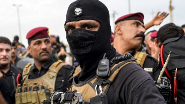 Iraqi security forces confront protesters during a demonstration against corruption and lack of basic services in the central Iraqi shrine city of Najaf (AFP)