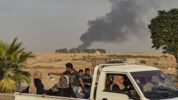 Civilians ride a pickup truck as smoke billows following Turkish bombardment on Syria's northeastern town of Ras al-Ain in the Hasakeh province along the Turkish border on October 9, 2019. (AFP/ File Photo)