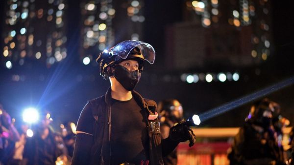 Riot police shine lights at protesters outside Ma On Shan police station in the New Territories of Hong Kong on October 9, 2019. (Anthony WALLACE / AFP)