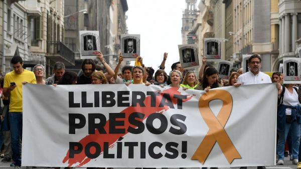 People protest holding a banner reading "Free political prisoners" in Barcelona on October 14, 2019, after Spain's Supreme Court sentenced nine Catalan leaders to prison terms ranging from nine to 13 years for sedition and misuse of public funds for their role in a failed 2017 independence bid. (LLUIS GENE / AFP)
