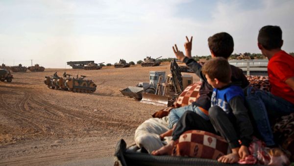 Syrian Arab civilians flash the victory sign as Turkish armoured personnel carriers and US-made M60 taks gather in the village of Qirata on the outskirts of the northern Syrian city of Manbij near the Turkish border, on October 14, 2019. (AFP/ File Photo)