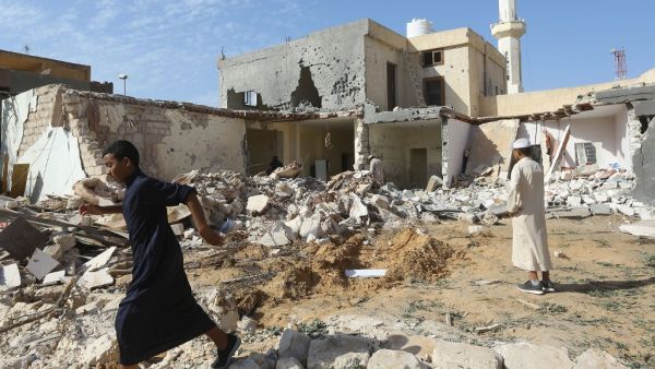 Libyans check the site of an air strike in which three children were killed and others wounded on the southern outskirts of the capital Tripoli (AFP)