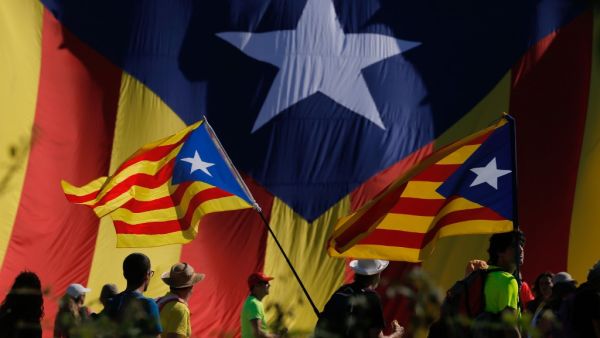 Protesters hold Catalan pro-independence "Estelada" flag as they walk on the AP-7 highway near Girona, on October 16, 2019, a day after police arrested 51 people across Catalonia overnight after violent protests over the jailing of nine separatist leaders for their role in a failed 2017 independence bid. (Pau Barrena / AFP)