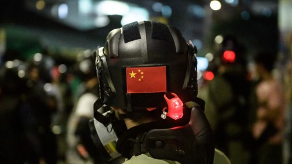 A Chinese flag is displayed on the back of the helmet of a riot police officer during a pro-democracy demonstrator in Yuen Long district of Hong Kong (AFP)