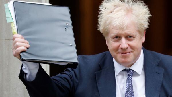 Britain's Prime Minister Boris Johnson reacts as he leaves from 10 Downing Street in central London on October 23, 2019, before heading to the House of Commons for Prime Minister's Questions (PMQS). British Prime Minister Boris Johnson said Tuesday he will pause efforts to pass his Brexit deal, after MPs gave their preliminary approval for it but rejected his timetable to push it through parliament this week. The president of the European Council, Donald Tusk, recommended that EU leaders postpone Britain's 