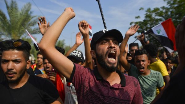 Iraqi protesters chant during an anti-government demonstration outside the Najaf governorate headquarters in the central shrine city, on October 27, 2019. Iraq's capital and country's south have been rocked by a second wave of demonstrations with protesters digging in despite tear gas, curfews and violence that has left over 60 dead. AFP