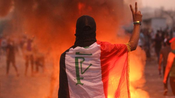 An Iraqi protester gestures the v-sign during a demonstration against state corruption, failing public services and unemployment at Tayaran Square in Baghdad. (AHMAD AL-RUBAYE/AFP)