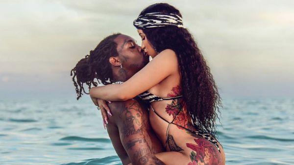 Cardi's long natural curls cascade over her shoulders in waves. 