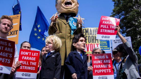 Anti Brexit protest. Stilts walker impersonating Nigel Farage holding puppets of Boris Johnson of Jeremy Hunt. (Shutterstock/ File Photo)