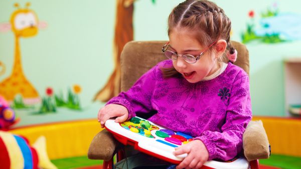 cute girl in wheelchair playing with developing toy in kindergarten for children with special needs (Shutterstock/ File Photo)