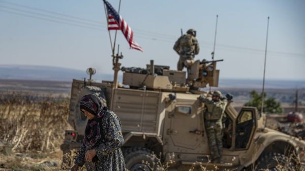 A Syrian elderly woman walks past a US armoured vehicle on patrol in the village of Ein Diwar in Syria's northeastern Hasakeh province on November 4, 2019.  Delil SOULEIMAN / AFP
