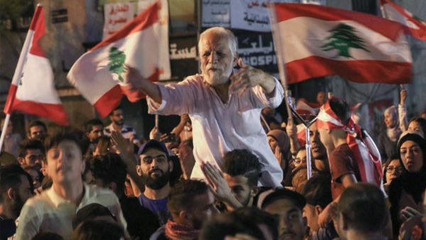 Lebanese protesters chant slogans and wave their country's national flag during ongoing anti-government demonstrations in Lebanon (AFP)