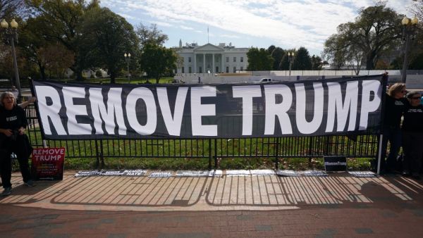 Activists hold a banner asking for the impeachment of US President Donald Trump on November 5, 2019 in front of the White House in Washington,DC. US voters headed to polls Tuesday in several states with governorships or legislatures at stake, in early tests of enthusiasm for and against President Donald Trump ahead of the 2020 elections. Mandel Ngan / AFP