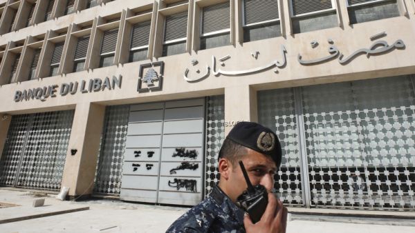 A member of the Lebanese security forces stands at the entrance of the Central Bank after anti-government protesters broke down a construction barrier as they rally at the same time of a press conference held by the bank's governor in Beirut on November 11, 2019. (AFP/ File Photo)