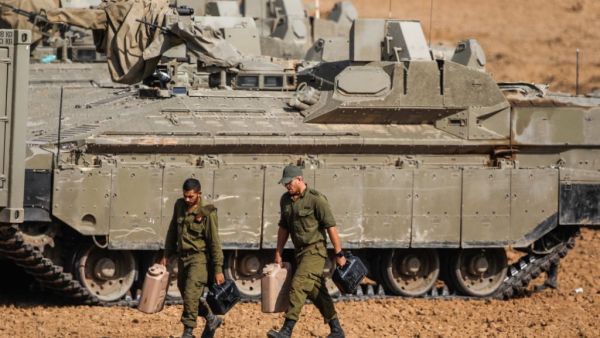 Israeli soldiers walk next to armoured vehicles near the border with the Gaza Strip on November 13, 2019. Israel launched deadly strikes against commanders of Palestinian militant group Islamic Jihad triggering a wave of tit-for-tat rocket salvos and air strikes that have killed 16 Palestinians in two days. (Menahem KAHANA / AFP)