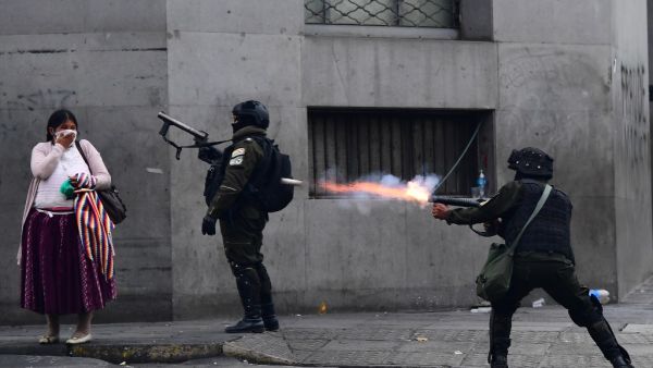Riot police fire tear gas to disperse supporters of Bolivian ex-President Evo Morales and locals discontented with the political situation during a protest in La Paz on November 13, 2019. Bolivia's exiled ex-president Evo Morales said Wednesday he was ready to return to "pacify" his country amid weeks of unrest that led to his resignation.  RONALDO SCHEMIDT / AFP