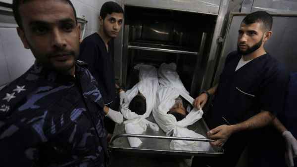 Palestinian police and morgue workers show the bodies of two of six members of the same family killed in an Israeli airstrike, at a morgue in central Gaza Strip's Deir al-Balah on November 14, 2019. Six members of the same family were killed in an Israeli airstrike on the southern Gaza Strip, the health ministry of the coastal Palestinian enclave said on November 14. The deaths bring the toll from Israeli strikes targeting Islamic Jihad militant sites to 32 since November 12, while 350 rockets have been fir