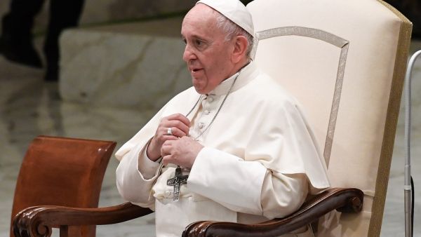 Pope Francis adjusts his iron cross necklace during an audience with students and teachers of Roma's LUMSA Catholic University, on November 14, 2019 at Paul-VI hall in the Vatican. Andreas SOLARO / AFP