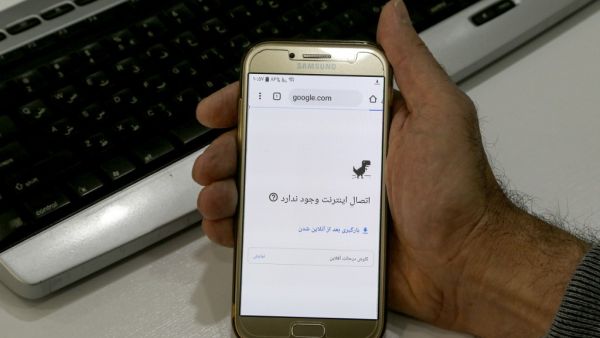A man holds a smartphone connected to a Wifi network without internet access at an office in the Iranian capital Tehran on November 17, 2019. (AFP)