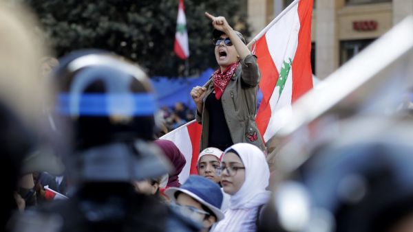 A Lebanese protester holds a national flag as she chants slogans during a demonstration at Riad al-Solh square near the government palace and the parliament headquarters in the capital Beirut's downtown district on November 19, 2019. (AFP/ File Photo)