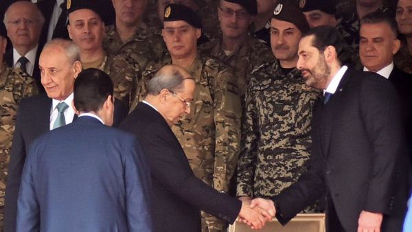 Lebanese President Michel Aoun (C) shakes hands with Prime Minister Saad Hariri (R) while Parliament speaker Nabih Berri (L) stands by, as they attend a military parade commemorating the 76th anniversary of Lebanese independence from France. (AFP/ File Photo)