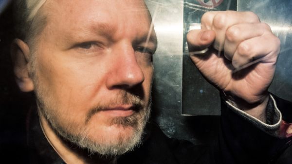 WikiLeaks founder Julian Assange gesturing from the window of a prison van as he is driven into Southwark Crown Court in London, before being sentenced to 50 weeks in prison for breaching his bail conditions in 2012. (AFP/ File Photo)