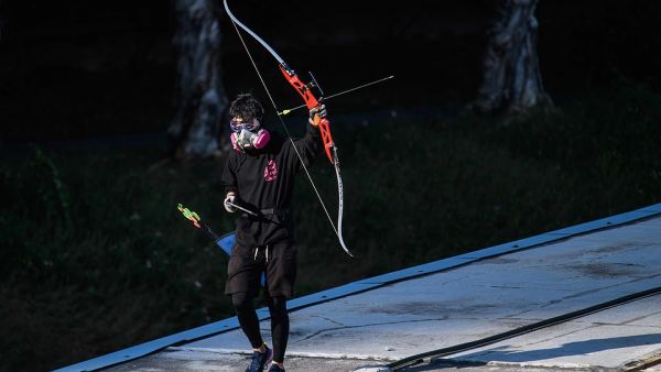 A protester wielding a bow and arrow walks along a footbridge roof. Hong Kong returned to Chinese rule under a 'one country, two systems' formula guaranteeing its colonial-era freedoms. (AFP/ File)