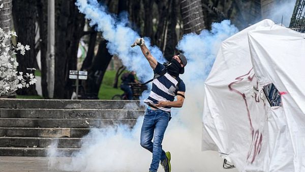 A demonstrator hurls a tear gas canister back to the riot police on the streets of Bogota yesterday. (AFP/ File Photo)