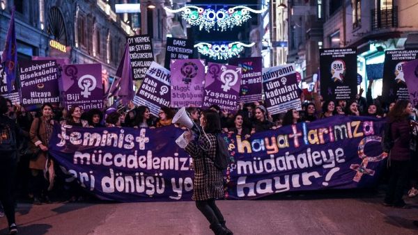 People hold signs as they march down Istiklal Avenue during a feminist night march to mark International Women's Day in Istanbul on March 8, 2017 (AFP Photo/OZAN KOSE)